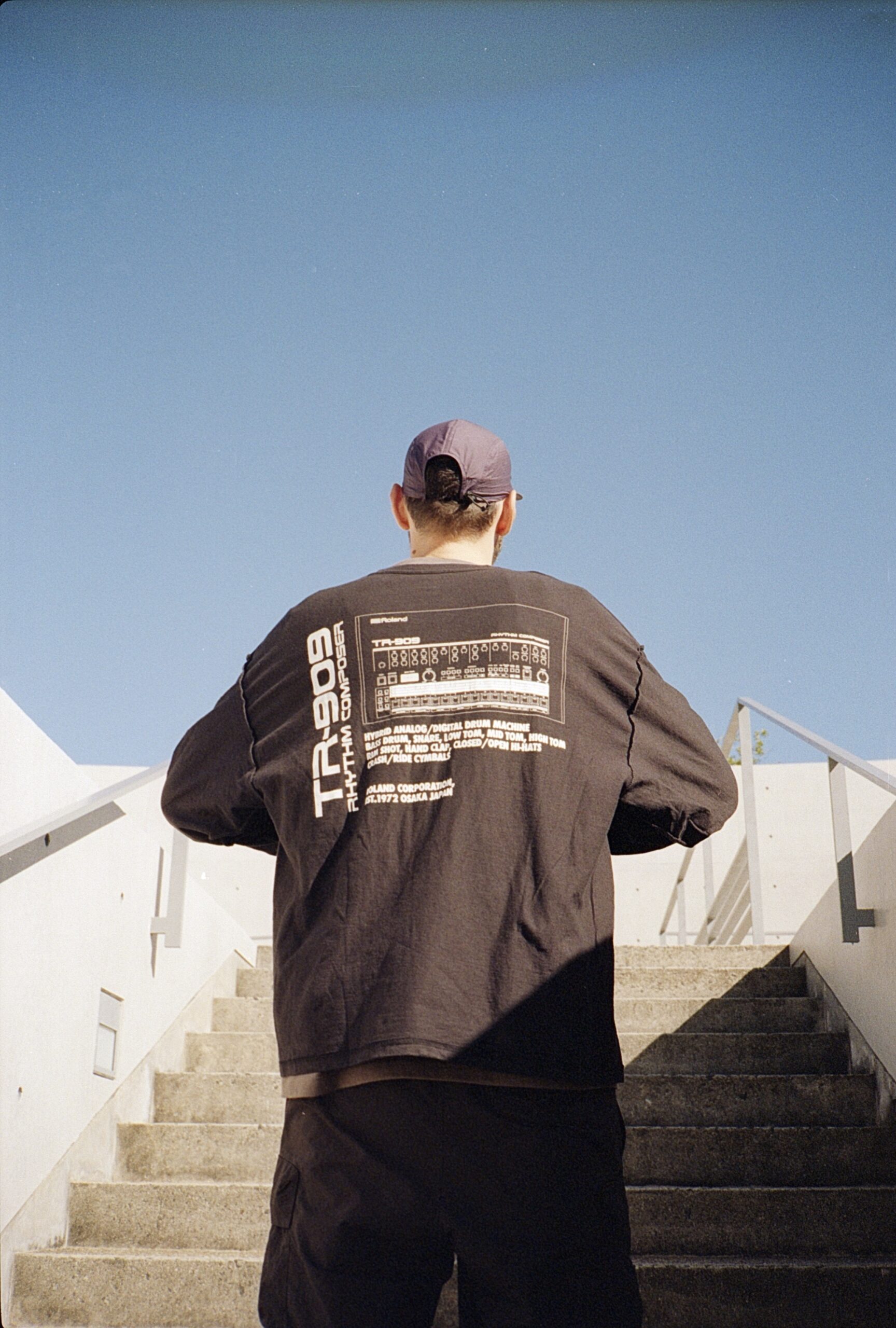 LVCA, co-founder of Sabotage Milano, seen from behind on an outdoor staircase.